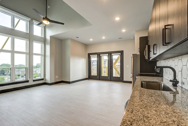 Spacious living room with modern decor and city views in Centro Railyard Apartments