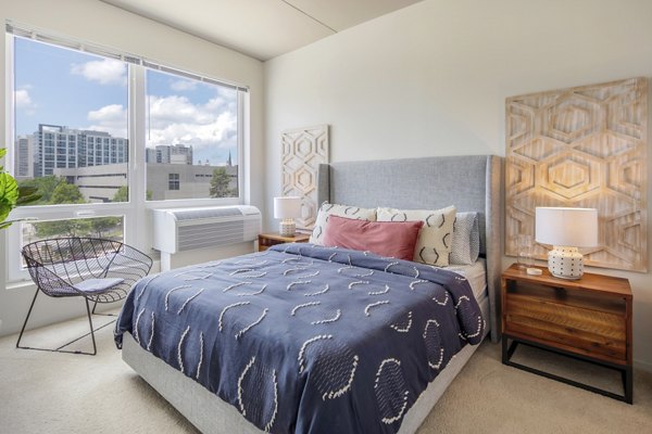 Elegant bedroom with plush furnishings at The Hamilton I Apartments in a well-appointed luxury setting