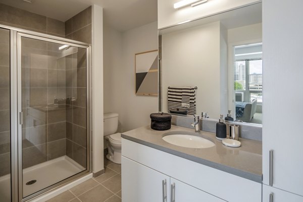 The Hamilton I Apartments: Modern bathroom featuring sleek fixtures and spacious design in luxury community
