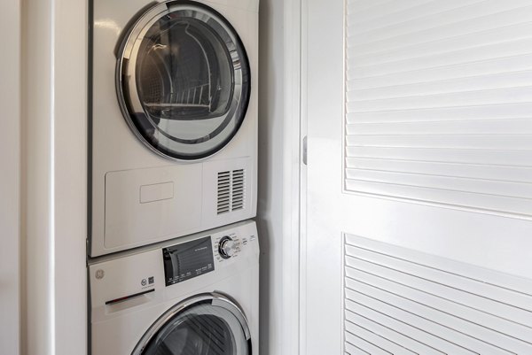 Laundry room with modern appliances at The Hamilton I Apartments, a Greystar luxury community