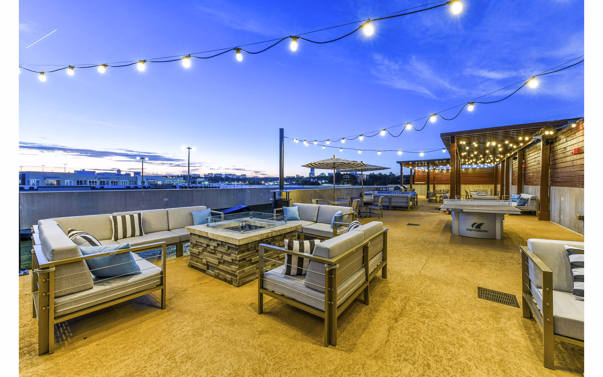 Outdoor lounge with fire pit and cozy seating at Newbergh ATL Apartments