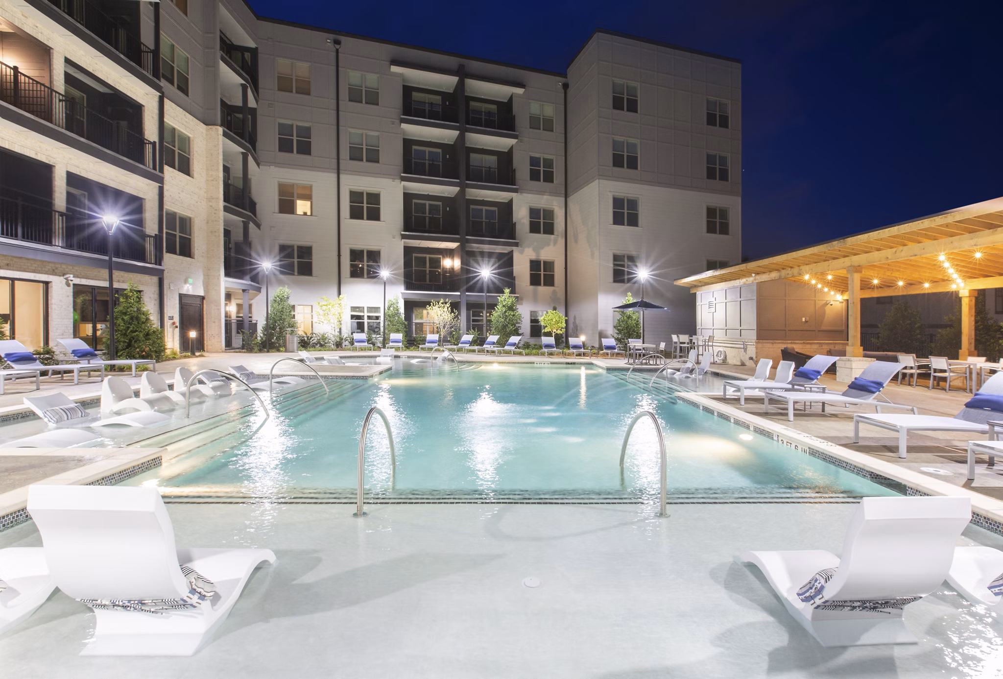 Resort-style pool with lounge chairs at Newbergh ATL Apartments, offering luxury living in a vibrant Atlanta community