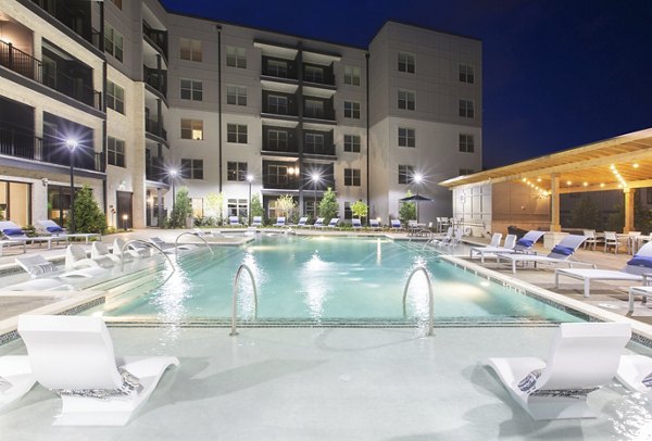 Resort-style pool with lounge chairs at Newbergh ATL Apartments, offering luxury living in a vibrant Atlanta community