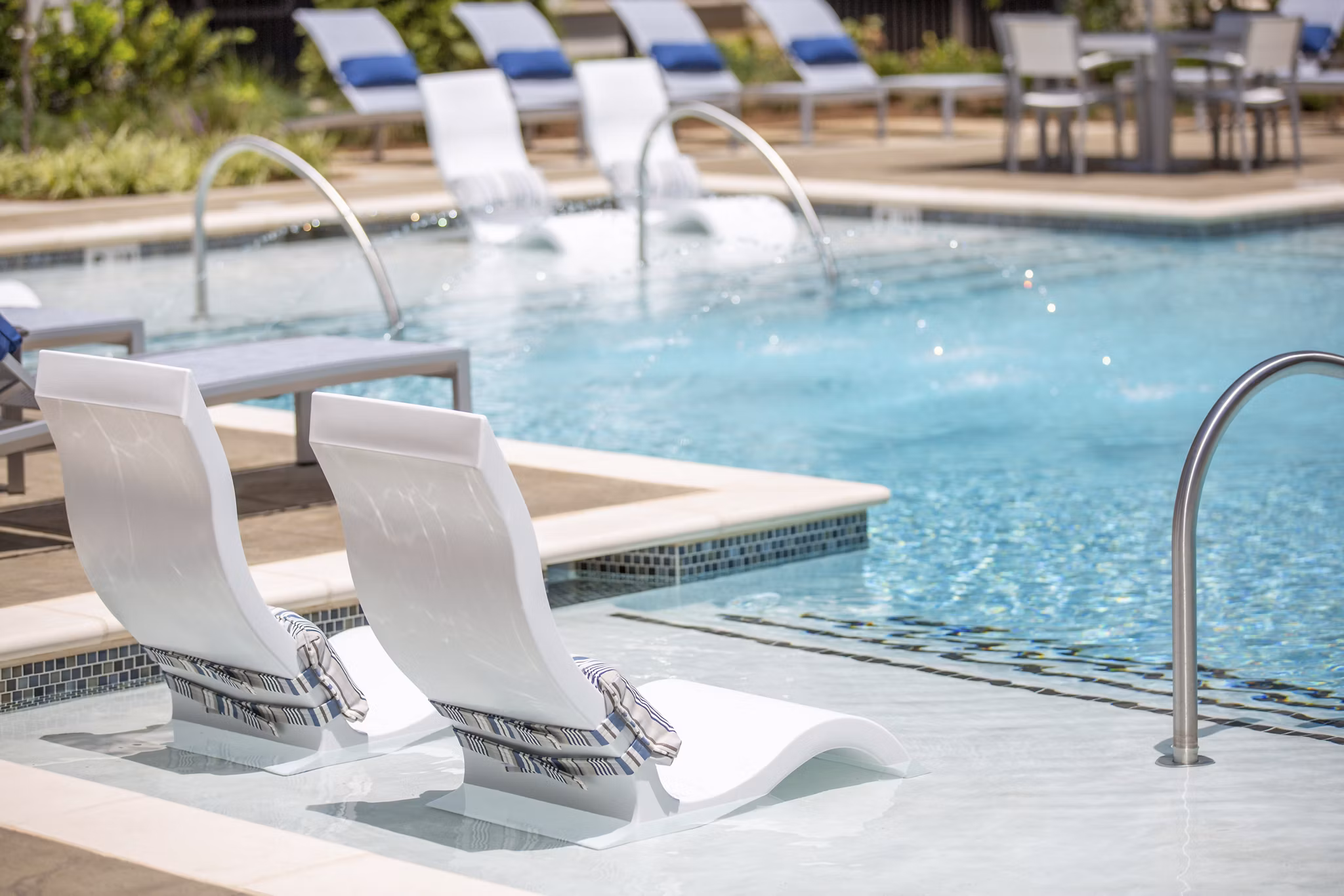 Resort-style pool at Newbergh ATL Apartments, featuring lush landscaping and sun deck areas