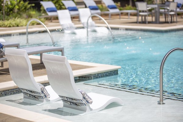 Resort-style pool at Newbergh ATL Apartments, featuring lush landscaping and sun deck areas