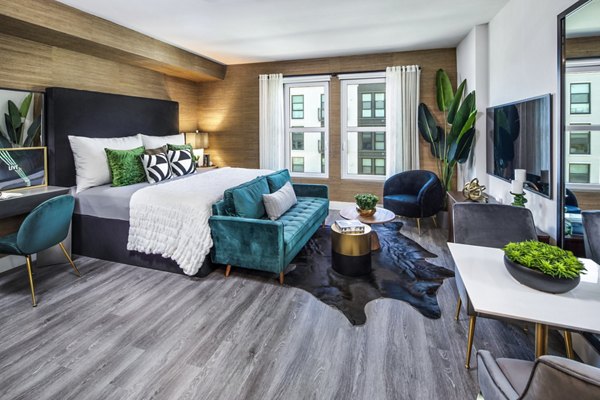 Bedroom featuring contemporary furniture and large windows at Highwater Apartments, a luxurious living community with premium amenities