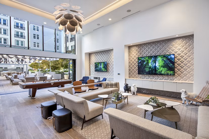 Game room with modern furnishings and pool table at Highwater Apartments luxury living