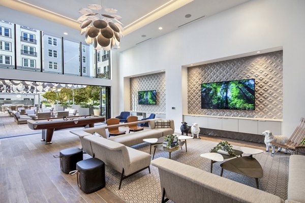 Game room with modern furnishings and pool table at Highwater Apartments luxury living