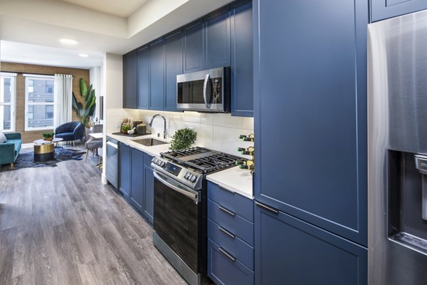Kitchen with modern stainless steel appliances and granite countertops in Highwater Apartments