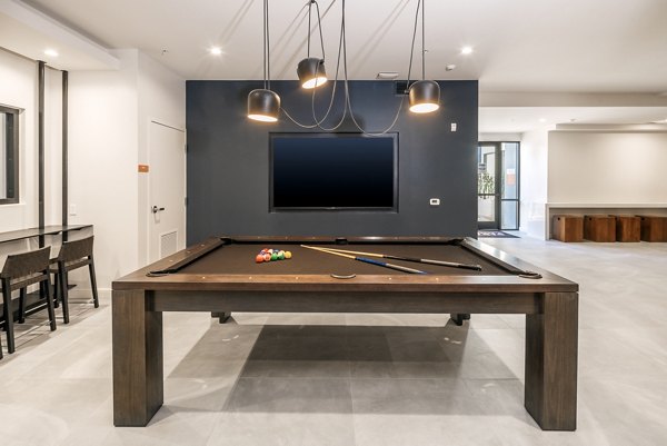 Game room with a pool table and TV in luxury apartments