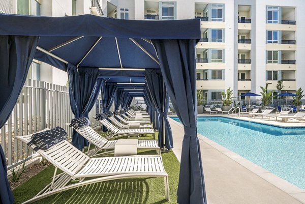 Modern outdoor pool with lounge chairs at Parallel Apartments luxury living