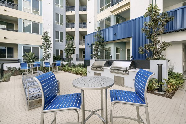 Grill area with modern seating and BBQ facilities at Parallel Apartments, perfect for outdoor dining and relaxation in the luxury community