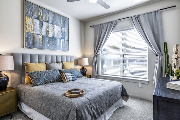 Bedroom with elegant decor and large windows at Overture River District Apartments