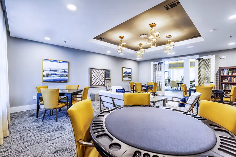 Clubhouse game room with billiards and lounge chairs at Overture River District Apartments, perfect for leisure and socializing