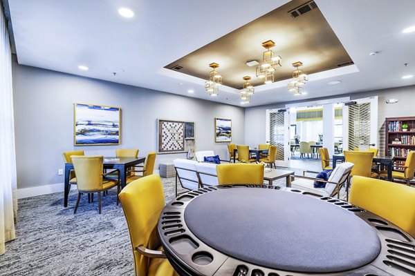 Clubhouse game room with billiards and lounge chairs at Overture River District Apartments, perfect for leisure and socializing