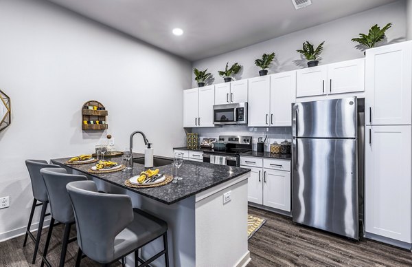 Modern kitchen with stainless steel appliances and granite countertops in Overture River District Apartments luxury residence