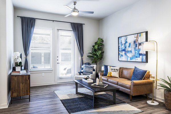 Living room with modern decor and natural light at Overture River District Apartments