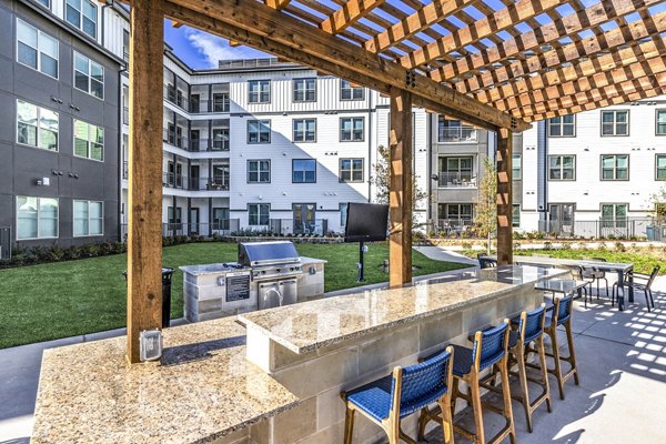 Outdoor patio grill area at Overture River District Apartments, perfect for social gatherings and dining in the open air