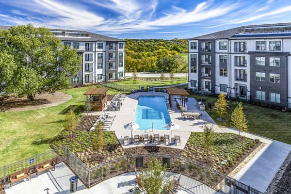 Outdoor pool with elegant seating at Overture River District Apartments in a serene environment