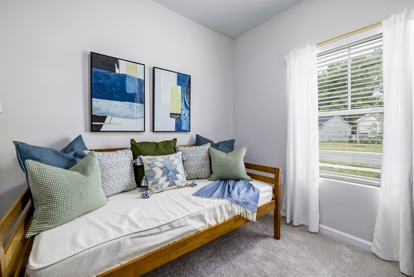 Spacious bedroom with soft lighting and modern decor in Abode at Geneva Apartment Townhomes