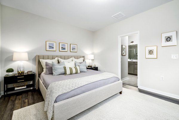 Cozy bedroom with modern decor and ample natural light in Abode at Geneva Apartment Townhomes