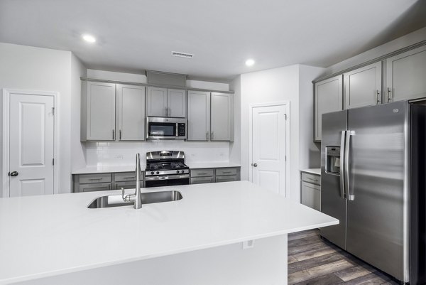 Modern kitchen with stainless steel appliances at Abode at Geneva Apartment Townhomes