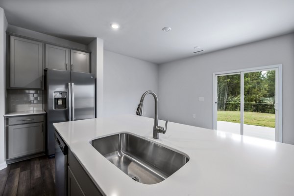 Modern kitchen with stainless steel appliances and granite countertops at Abode at Geneva Apartment Townhomes