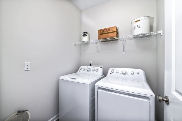 Laundry room featuring modern washers and dryers in Abode at Geneva Apartment Townhomes