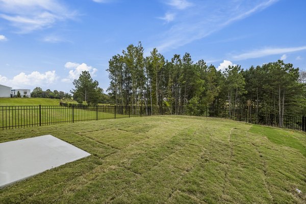 Backyard patio with modern seating and garden views at Abode at Geneva Apartment Townhomes