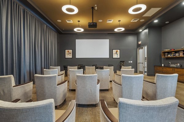 Clubhouse theater with plush seating and large screen at Album Cooley Station Apartments, a luxury living space for community entertainment