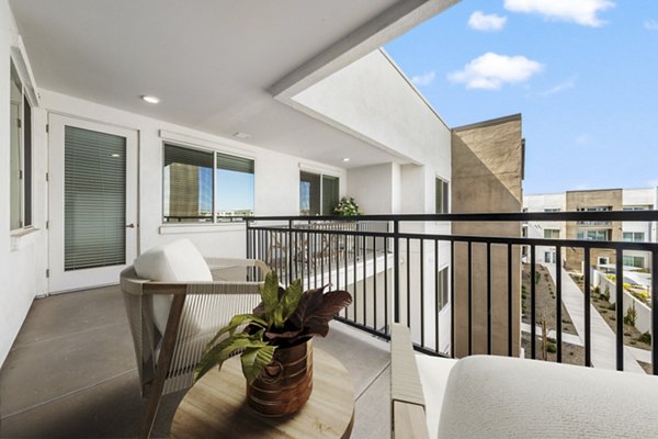 Spacious balcony with seating overlooking cityscape at Album Cooley Station Apartments