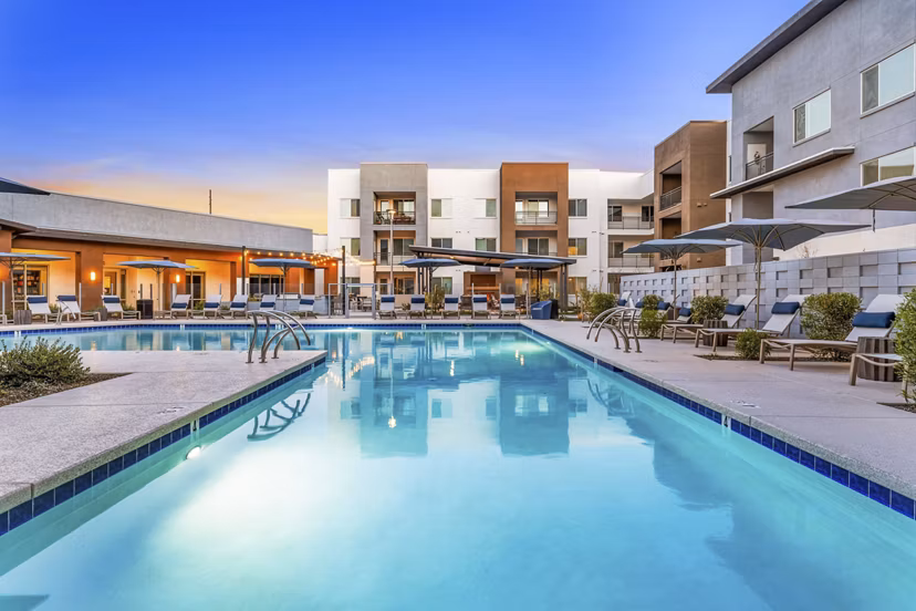 Resort-style pool surrounded by lounge chairs at Album Cooley Station Apartments