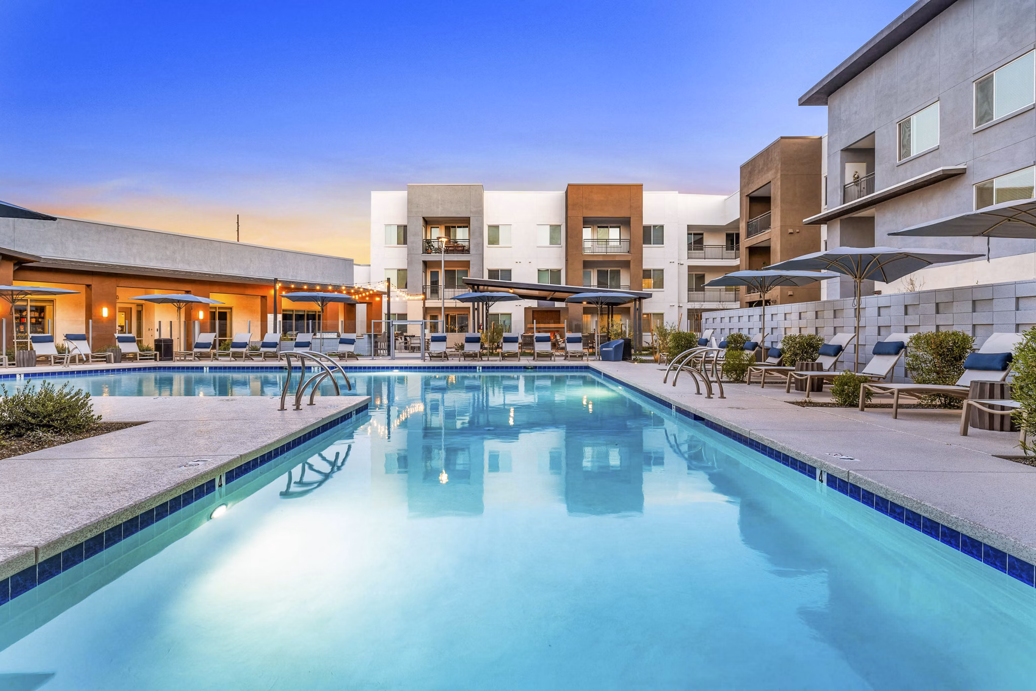 Resort-style pool surrounded by lounge chairs at Album Cooley Station Apartments