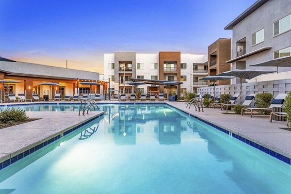 Resort-style pool surrounded by lounge chairs at Album Cooley Station Apartments