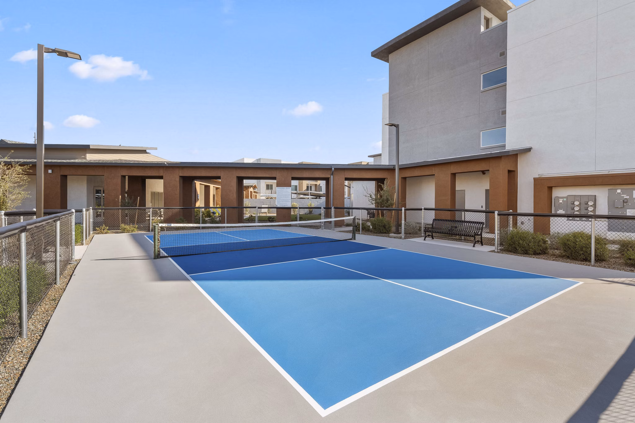 Outdoor tennis court at Album Cooley Station Apartments offering well-maintained facilities for active living in a vibrant community setting