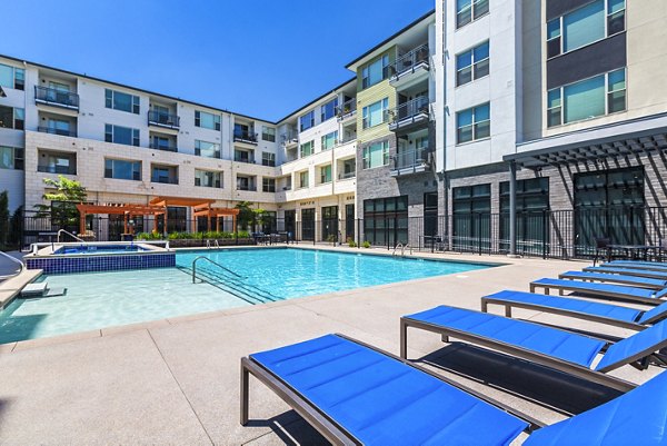 Relaxing poolside retreat at Solana Lakewood Apartments with luxurious seating and landscaped surroundings