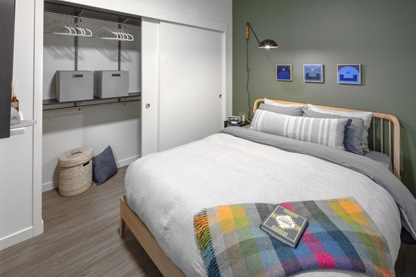 Spacious bedroom with modern decor and ample natural light at Sawbuck Apartments