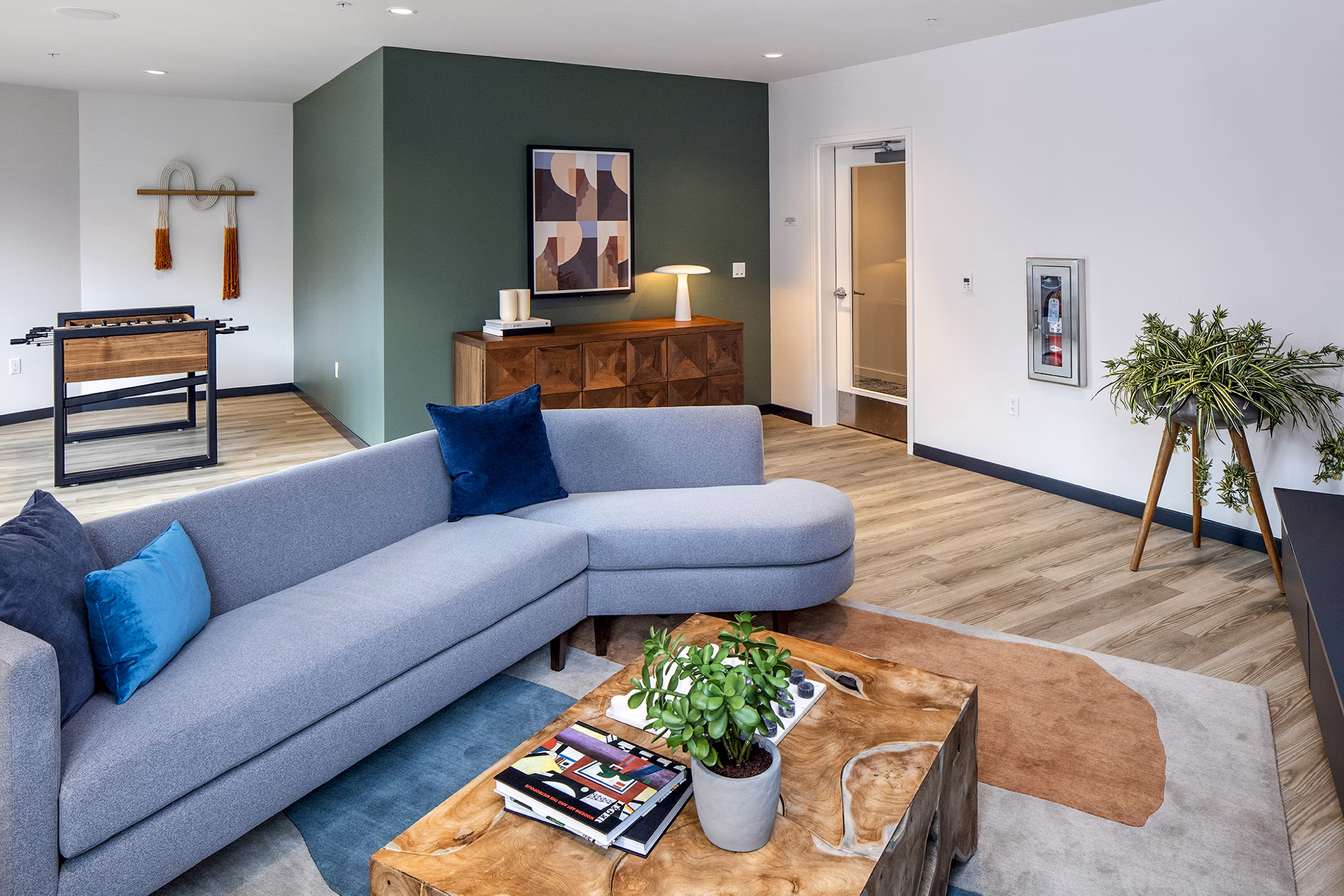 Modern game room with pool table and lounge seating at Sawbuck Apartments