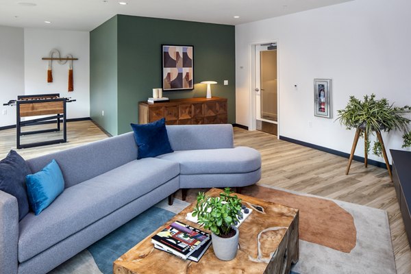 Modern game room with pool table and lounge seating at Sawbuck Apartments