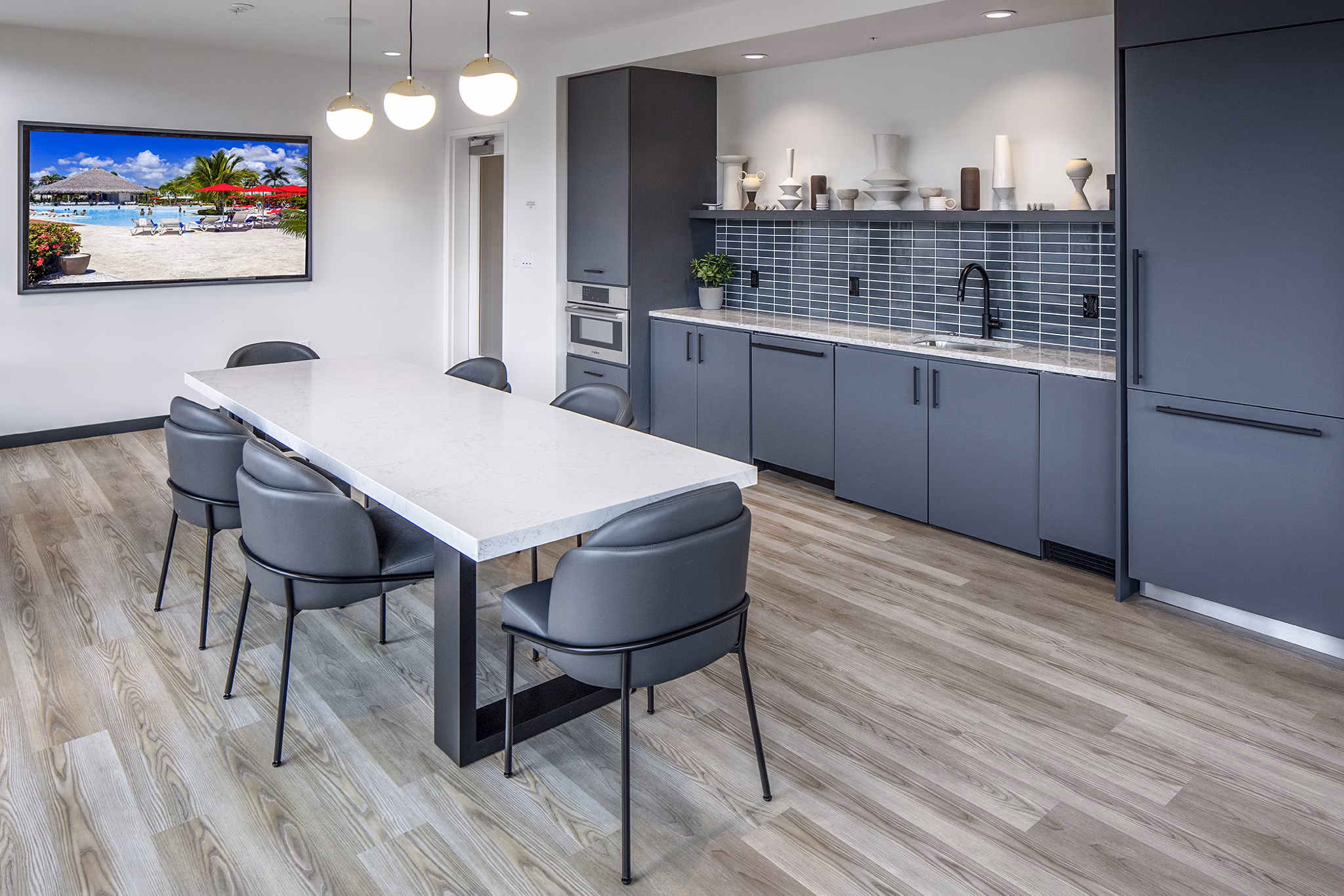 Clubhouse kitchen featuring modern appliances and island seating at Sawbuck Apartments luxury community