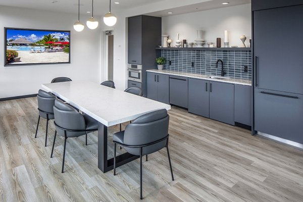 Clubhouse kitchen featuring modern appliances and island seating at Sawbuck Apartments luxury community