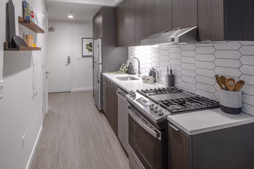 Modern kitchen with stainless steel appliances in Sawbuck Apartments