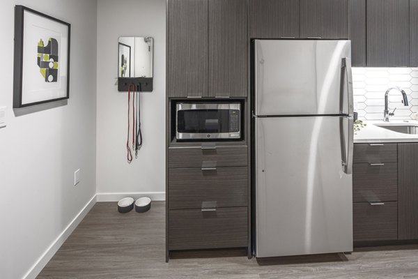 Modern kitchen with stainless steel appliances in Sawbuck Apartments, a luxury Greystar property