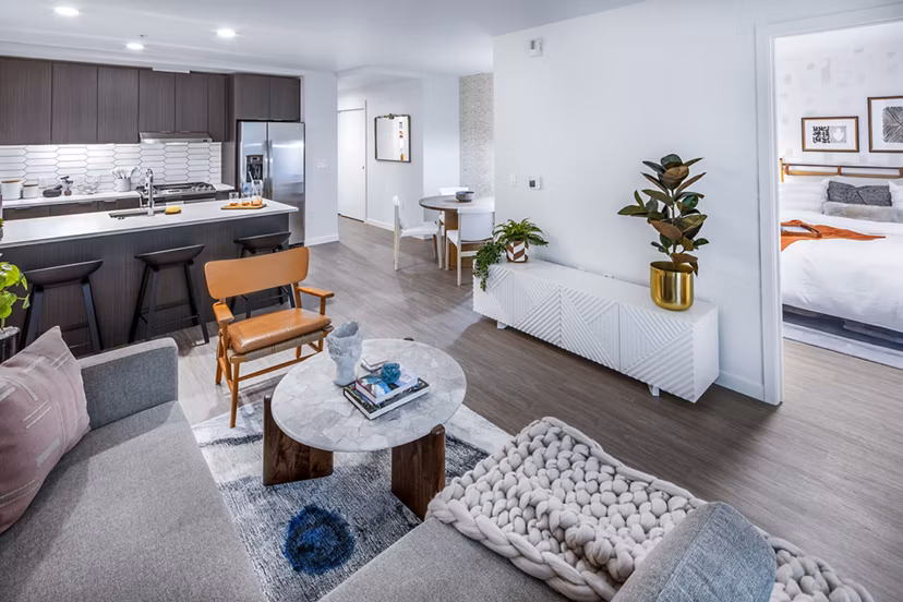 Spacious living room with modern decor and large windows in Sawbuck Apartments