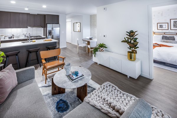 Spacious living room with modern decor and large windows in Sawbuck Apartments