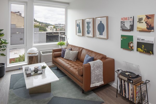 Modern living room with sleek decor and ample natural light at Sawbuck Apartments, showcasing luxury living in a Greystar community