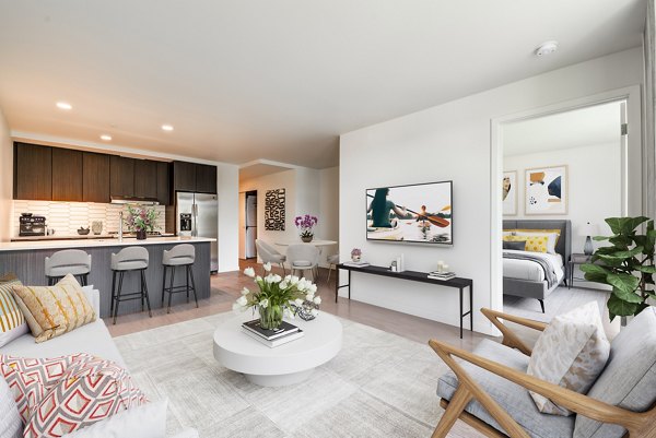 Modern living room with cozy furnishings and abundant natural light at Sawbuck Apartments