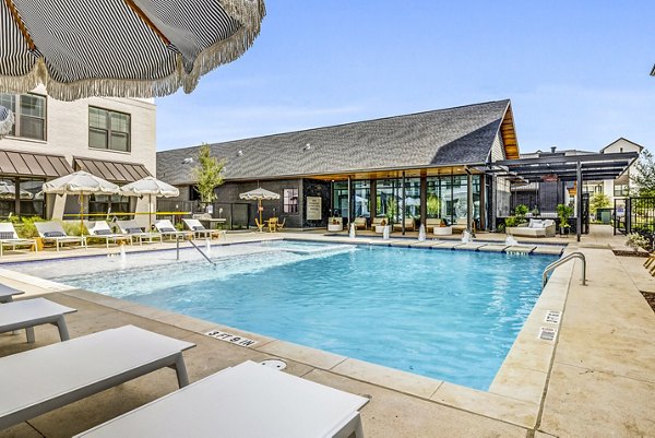 Luxurious pool surrounded by lounge chairs at Laurel Apartment Homes