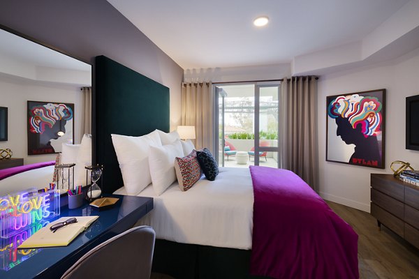 Cozy bedroom featuring modern decor and ample natural light at Mode Apartments