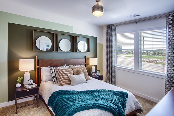 Bedroom with stylish decor featuring a king bed and large windows at Ascend at Prairie Village luxury apartments